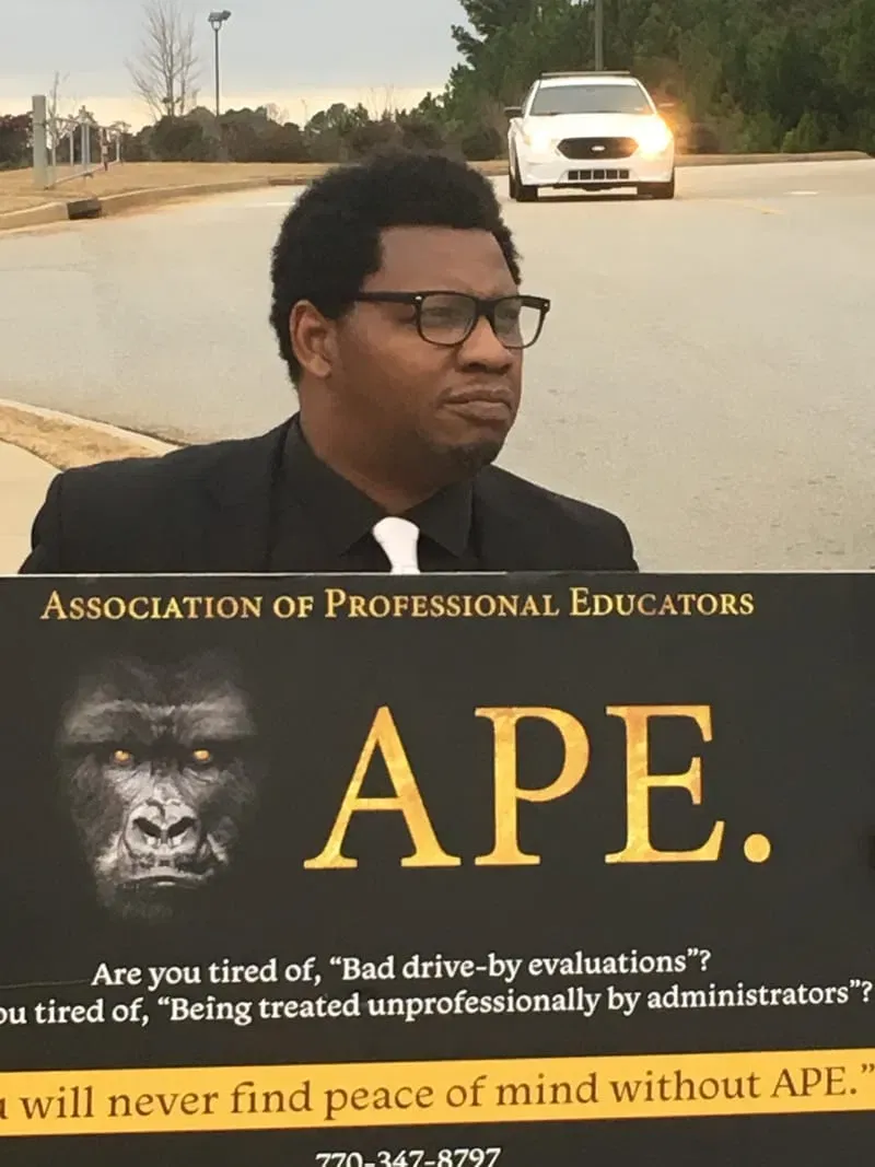 A professional educator holding an A.P.E. advocacy sign